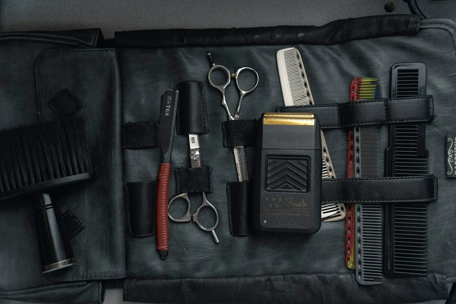 Estuche con tijeras, peines y máquina del salón